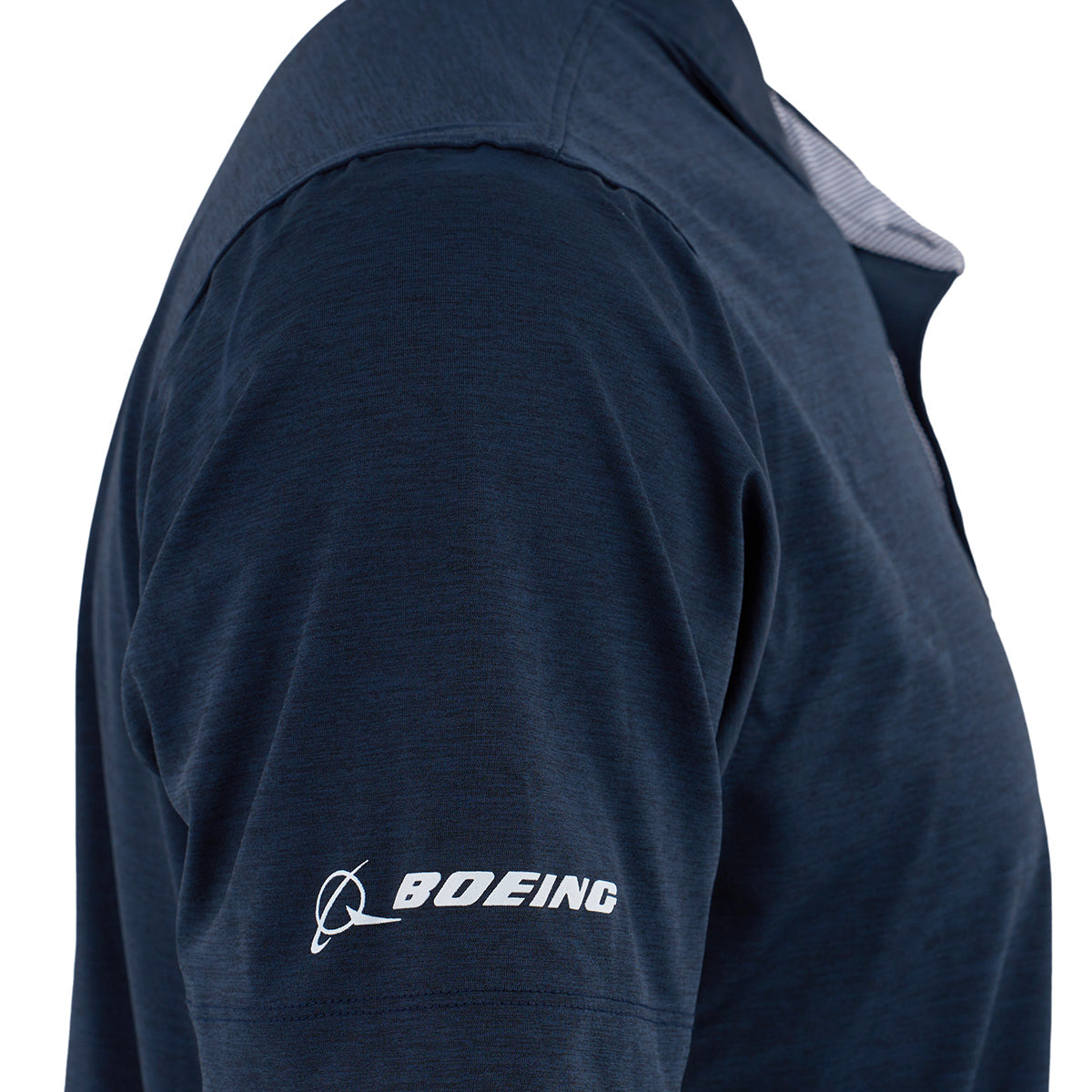 A close-up of a person’s upper arm and shoulder wearing the Boeing F/A-18 Super Hornet Series Men’s Polo by BOEING, featuring a navy blue moisture-wicking fabric and the white Boeing logo printed on the sleeve.